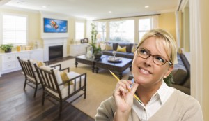 Attractive Daydreaming Woman with Pencil Inside Beautiful Living Room.