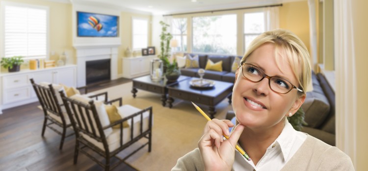 Attractive Daydreaming Woman with Pencil Inside Beautiful Living Room.